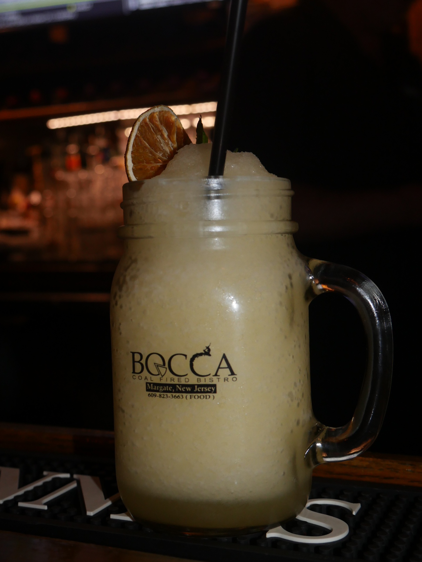 Frozen cocktail served in a Bocca mason jar with orange garnish