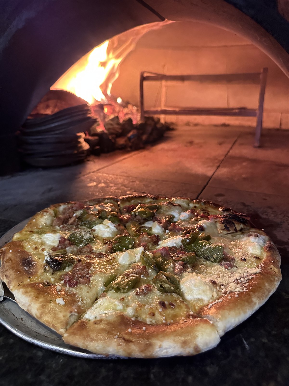 Kids stretching and topping their own pizzas at Bocca's coal oven